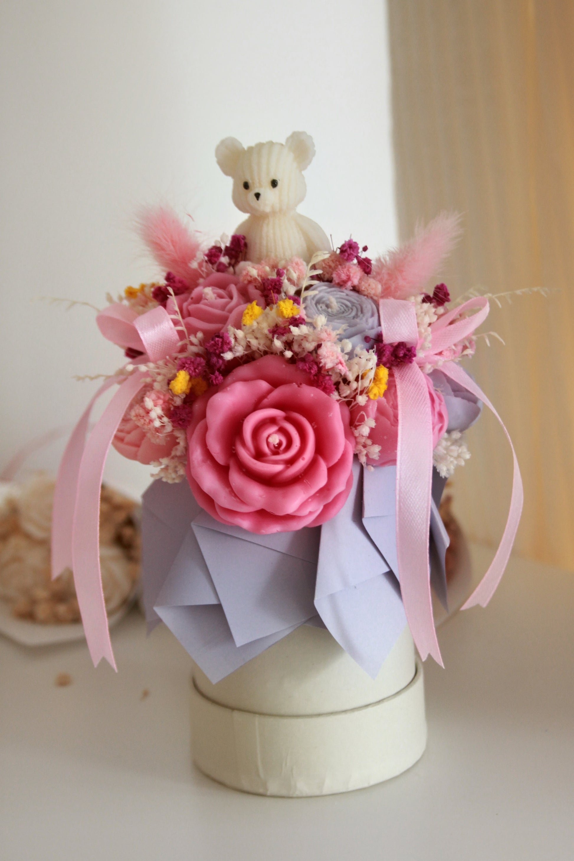 Mini flower box z różową świecą sojową, suszonymi kwiatami i białą figurką misia — prezent na Dzień Dziecka