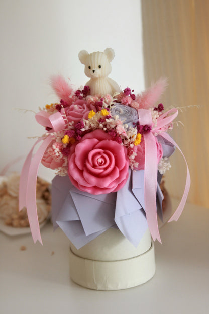 Mini flower box z różową świecą sojową, suszonymi kwiatami i białą figurką misia — prezent na Dzień Dziecka